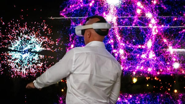 A delegate in a VR headset in front of a starfield display on the Pawsey tour